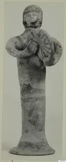 Terracotta figurine of a standing figure holding a round disc with radiating lines, from Ayia Irini.