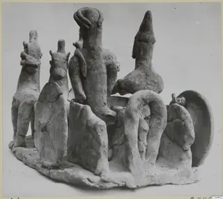 Terracotta group of several figurines on an irregular oval base, from Ayia Irini, photographed from a three-quarter angle