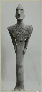 Terracotta figurine of a standing figure with a cap-like head and an incised chevron pattern across the chest