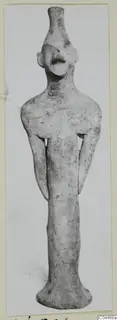 Terracotta figurine standing upright, with a long neck, small head and arms held close to the body