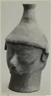 Terracotta vessel in the form of a human head with a tall flared neck, from Ayia Irini