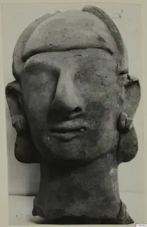 Terracotta head with a broad band across the forehead, a long straight nose and large flat ears with small ear ornaments