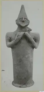 Terracotta figure with a tall cylindrical body, pointed conical head and arms folded across the chest