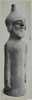 Terracotta figure of a standing human form with a tall conical head-top, from Ayia Irini