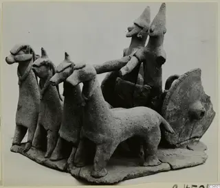 Terracotta model of a two-wheeled vehicle drawn by four animals, with two standing figures in the cart