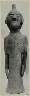 Terracotta standing figure with short stubby arms and a knob on top of its head, seen from the front.