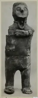 Terracotta figurine of a standing human figure with arms folded across the chest