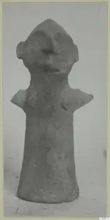 Terracotta figurine with a cylindrical body, pointed head, ear-like projections and flat shoulders, shown against a plain background