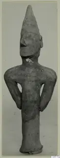 Terracotta figurine of a standing human figure with a tall pointed head and arms bent at the sides, from Ayia Irini