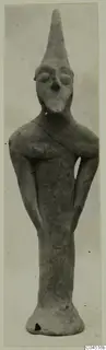 Terracotta figurine from Ayia Irini with a tall conical head and bent arms, standing upright