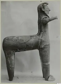 Terracotta figure with a human-like head on an animal-like body, shown in side view against a plain grey background.