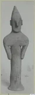 Terracotta figurine of a standing human figure with a pointed head, small ears, arms bent at the sides.