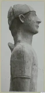 Terracotta statue of a figure's head and shoulder in side profile, with incised lines on the shoulder