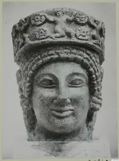 Limestone head with a tall decorated headdress and braided hair, from Arsos
