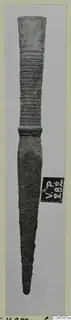Bronze weapon with a ribbed socket and long tapering blade, photographed upright against a pale grey background