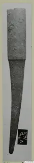 Corroded bronze object from Vouni, with a broad upper section tapering to a point.