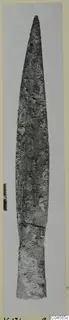Long pointed bronze blade, a weapon from Vouni, photographed upright on grey card