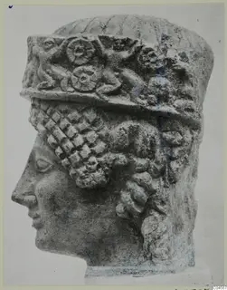 Limestone head from a statue from Arsos, in profile facing left, wearing a tall headdress with a carved relief band