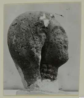 Limestone head from Arsos, shown from a side angle on a square base