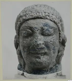 Limestone head of a sculpture from Arsos, face forward, with a band across the top of the head.