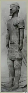 Terracotta Proto-Cypriote I, a full-length standing bearded male statue with arms at its sides and a close-fitting cap.