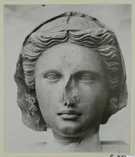 Marble head of a young woman with wavy hair swept back, the nose broken away