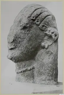 Limestone head sculpture in three-quarter view, with a raised hair band and rounded ear ornament