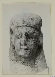 Limestone sculpture of a head with a flat cap and rounded ears, Proto-Cypriote, shown frontally