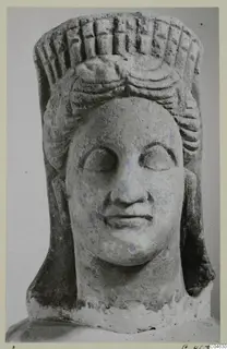 Stone statue head with a tall grooved headdress, from Arsos