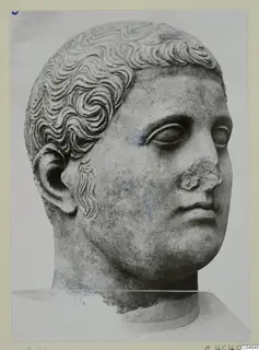 Carved stone head from Arsos, shown in three-quarter view with curled hair and a broken nose.
