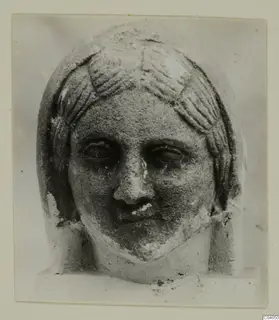 Stone statue head from Arsos, face and hair in front view, nose and lips worn.