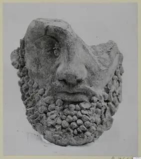 Terracotta head from Mersinaki with a broad nose and a beard of rounded knobs, shown from the front.