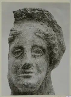 Head of a stone statue from Mersinaki, with a weathered face and a thick mass of hair.