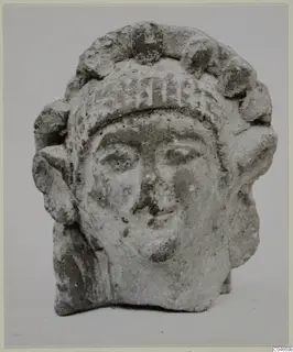 Sculpted head with a crown of rounded knobs and side curls, from Mersinaki, photographed against a plain background