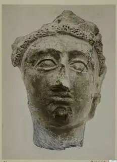 Head of a figure from Mersinaki with a ridged headband, almond-shaped eyes and a chipped nose, seen from the front.