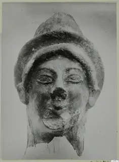 Head from Mersinaki with a tall, banded cap, large eyes and a damaged nose, neck broken off at the base