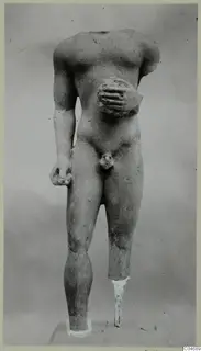 Limestone statue of a standing male nude, headless and with broken limbs, from Mersinaki.