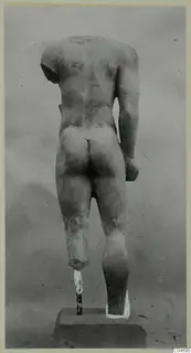 Back view of a headless limestone statue of a standing male figure, from Mersinaki