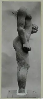 Limestone statue of a standing male nude from Mersinaki, seen from the side with one arm bent across the body