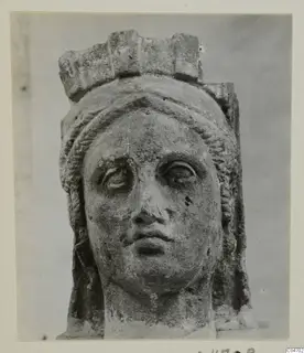 Stone head from Arsos with a flat crown-like top and wavy hair framing the face