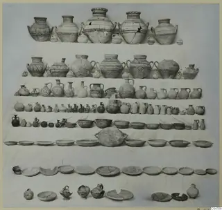 Pottery vessels from Tomb 8 at Amathus: jars, jugs, bowls and plates laid out in rows on a white cloth.