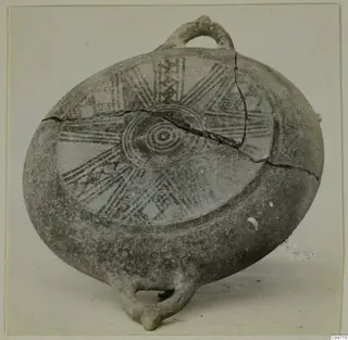 Flattened round pottery vessel with a loop handle and painted radiating bands, from Amathus