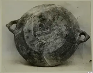 Pottery Black Slip Bichrome vessel with two loop handles, seen from above, with painted concentric circles and radiating bands
