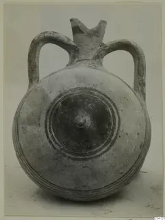 Pottery Bichrome III vessel with two loop handles, a round body and concentric ring decoration around a central boss