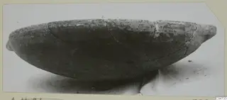 Pottery Red Slip bowl, shallow and wide, photographed in side view with small projections at each end