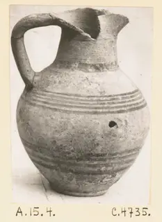 Pottery jug with a strap handle, a broken rim and dark horizontal bands on the body, catalogued as White Painted III-1