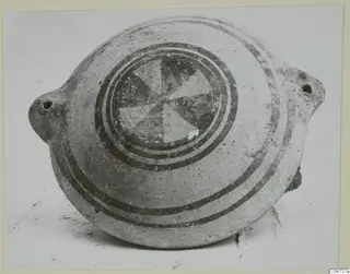 White Painted II pottery vessel from Amathus, flattened round body with pierced lugs, painted bands and a central segmented motif
