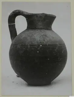 Pottery jug with a loop handle and dark banded decoration, from Amathus tombs, shown on a photo mount