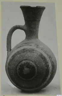 Pottery jug with a flaring neck, a single loop handle and concentric bands on the rounded body