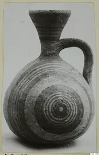 Pottery White Painted IV jug with a flaring neck, strap handle and concentric circles painted on the body